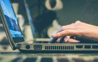 maini care tasteaza la un laptop