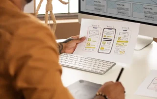 Designer UX care analizează wireframe-uri pentru interfețe mobile, în procesul de creare site web